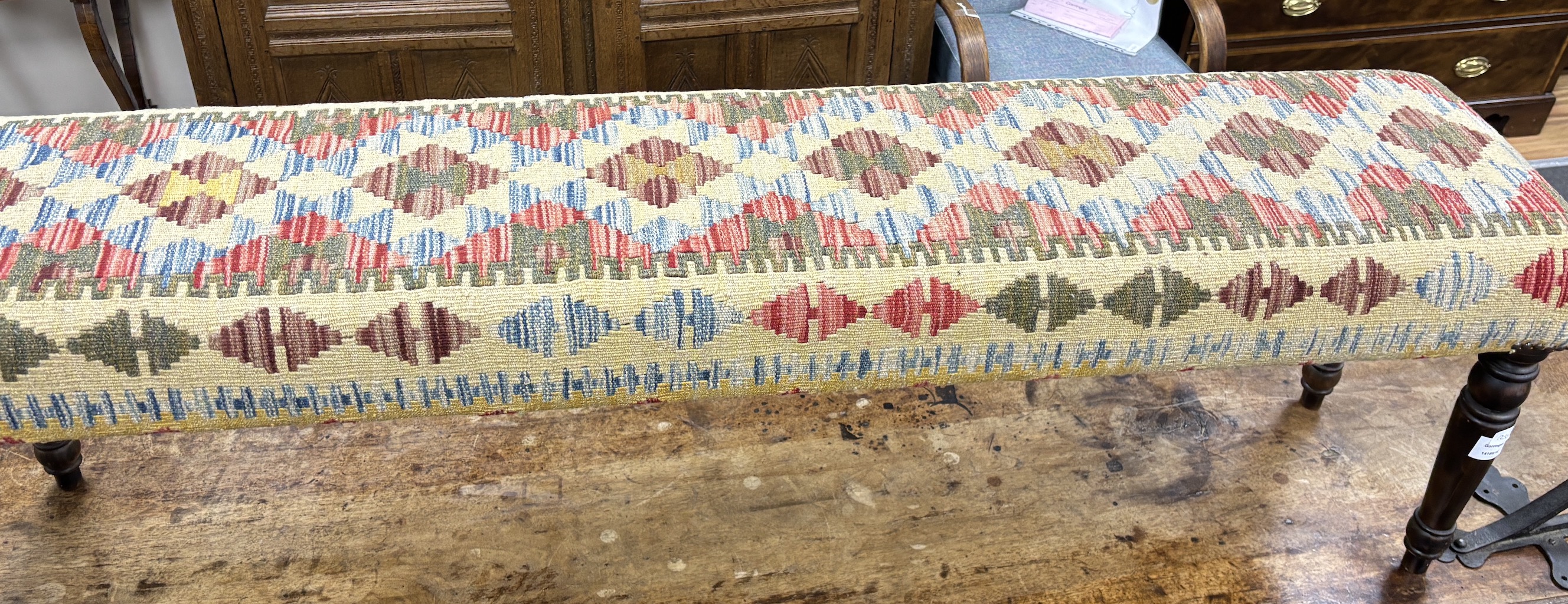 A Kilim covered long stool on turned beech legs, width 153cm, depth 34cm, height 47cm